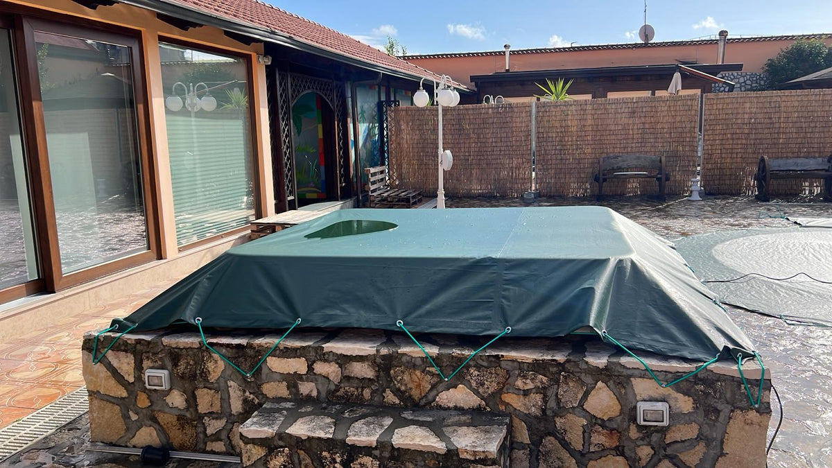 Telo di copertura invernale occhiellato fissato con corda elastica su piscina